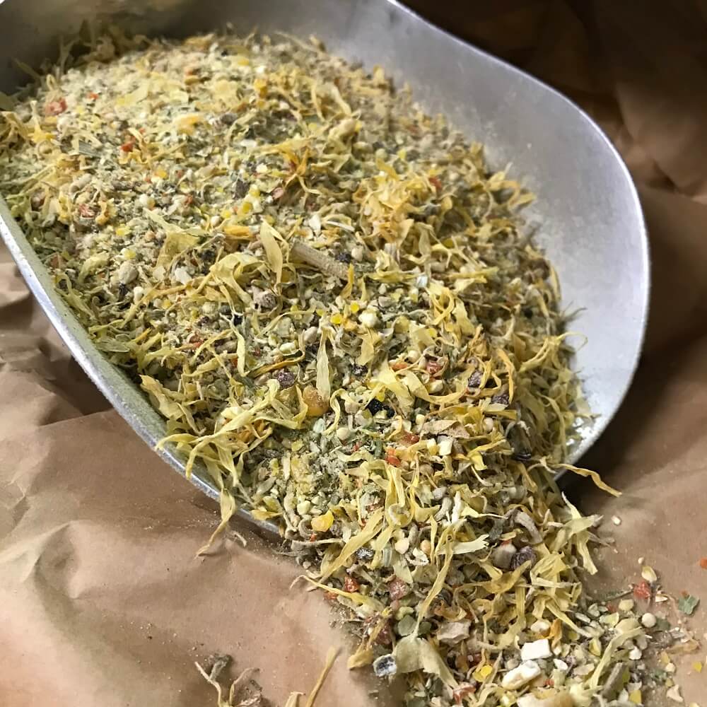 Kükenstarter mit Kräutern und Blüten